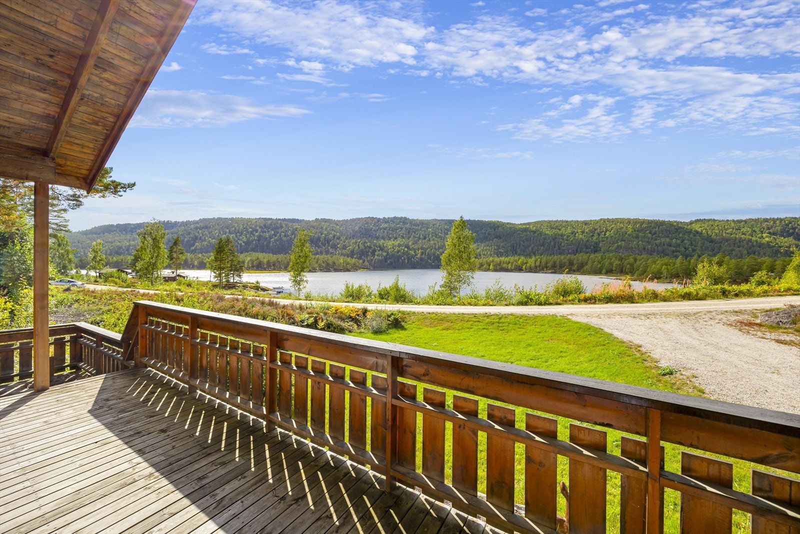Solrik terrasse med panoramautsikt over innsjø og skogkledde åser. - Her kan du nyte både morgenkaffe og solnedgang. Galleribilde