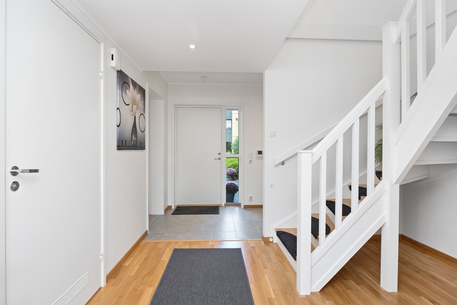 Det er fliser og gulvarme i første del av gangen, og parkett videre innover i leiligheten. Ellers downlights i nedsenket himling og lysmalte slette vegg- og takflater Galleribilde