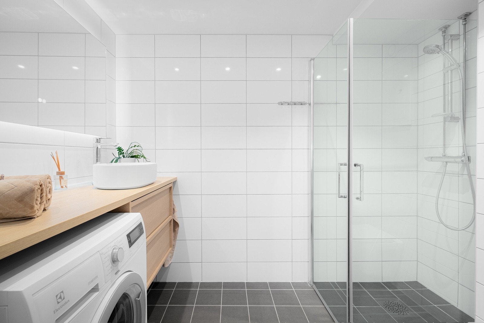 Leiligheten har et lyst og moderne flislagt baderom som ble pusset opp i regi av brl. i 2020. Baderommet har mørke fliser på gulv med gulvvarme, hvite fliser på veggene, downlights i himlingen og mekanisk avtrekk. Galleribilde
