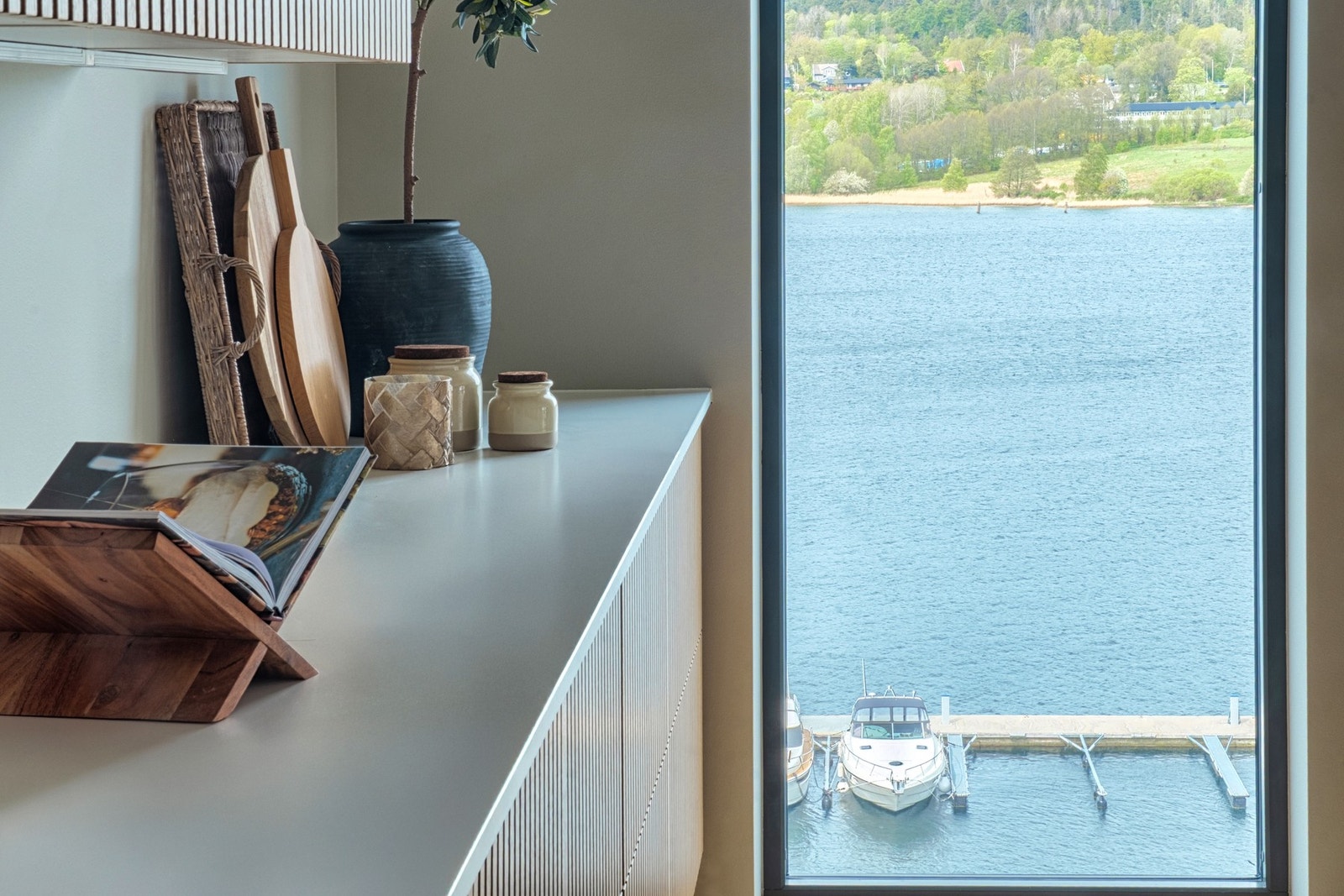 Vinduene i leiligheten rammer inn sjø og land som et maleri Galleribilde