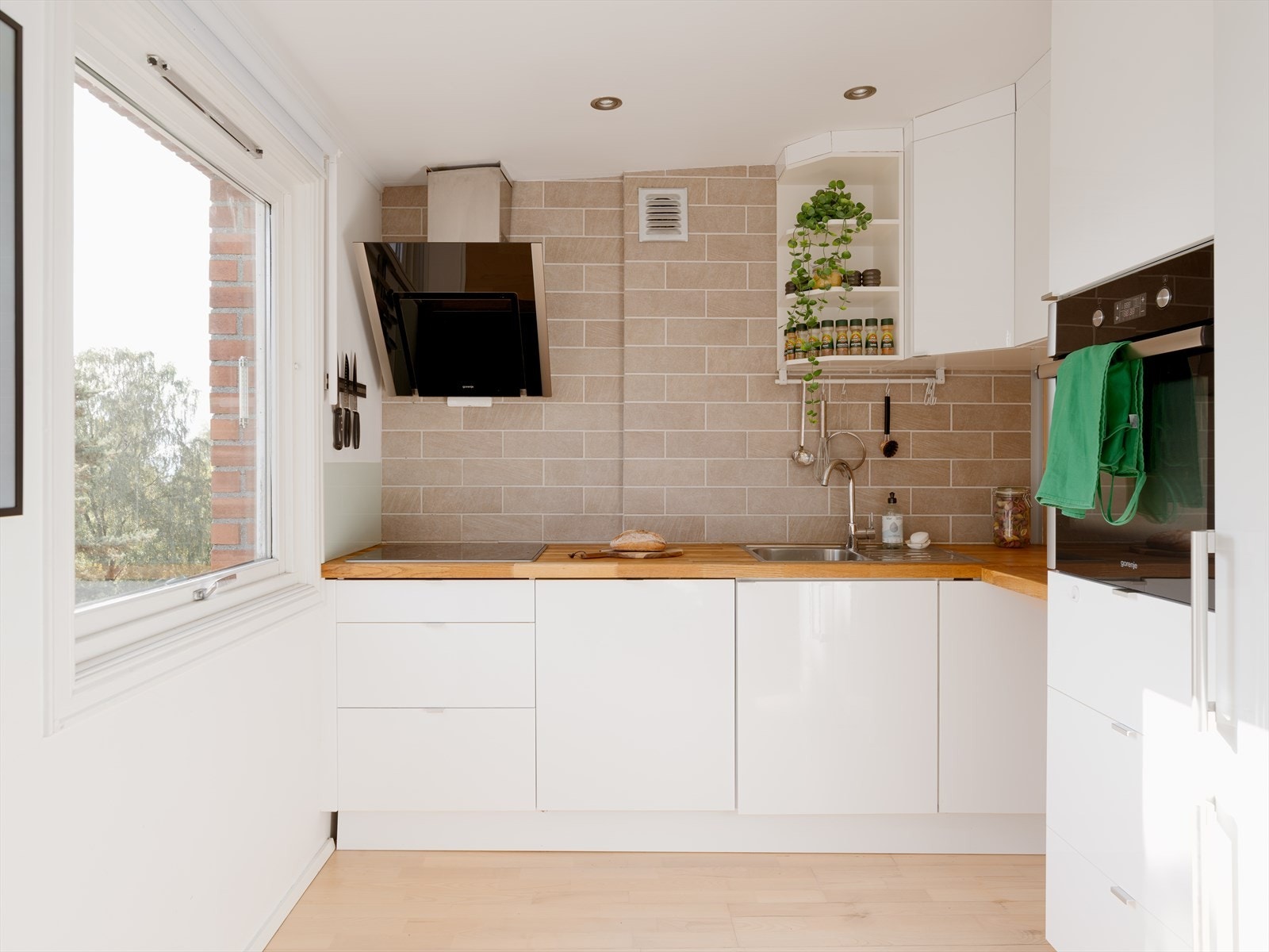 Kjøkkenet er innredet med integrerte hvitevarer, og byr på godt med plass til oppbevaring i overskap og underskuffer. Vindusflatene slipper inn rikelig med naturlig lys. Galleribilde