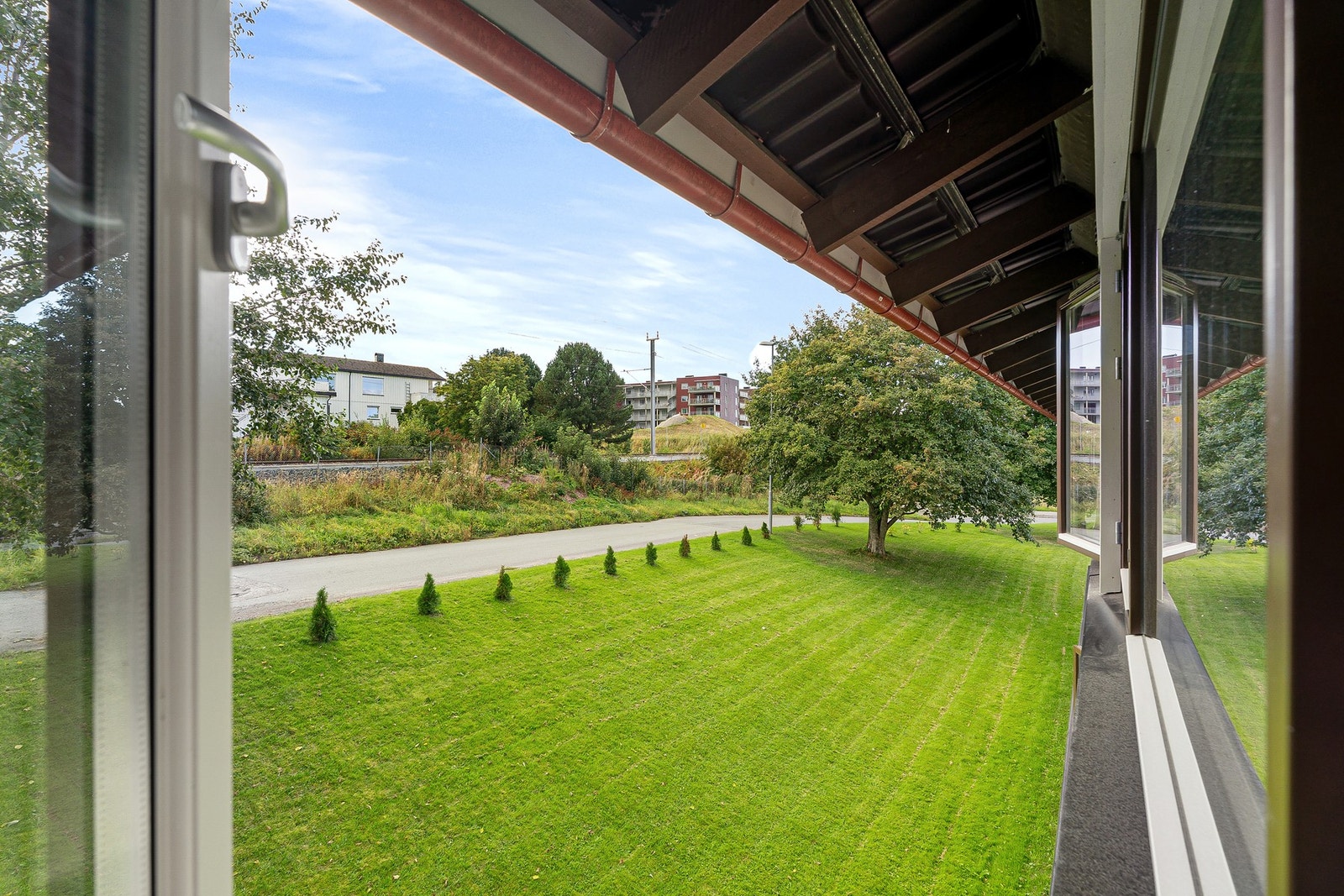 Fra leiligheten har man også utsikt mot pene grøntarealer med sol på dagtid. Galleribilde