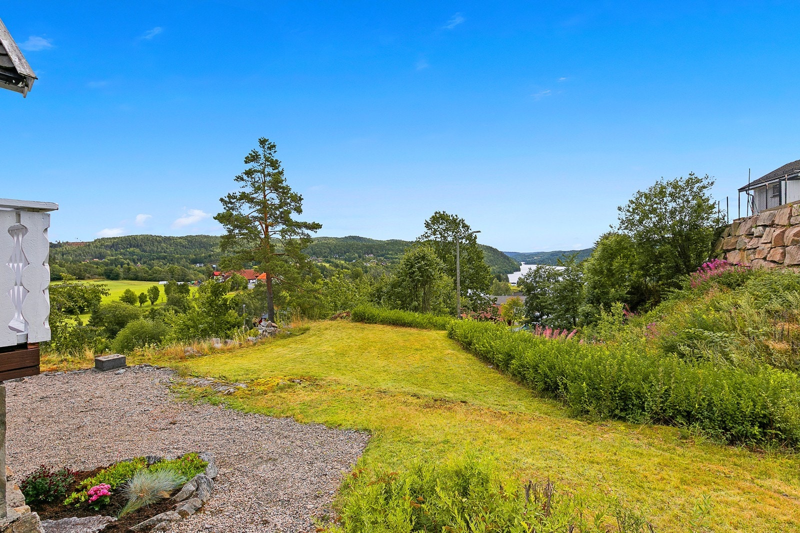 Flat og fin hage på sørvestsiden av boligen med sol hele dagen. Galleribilde