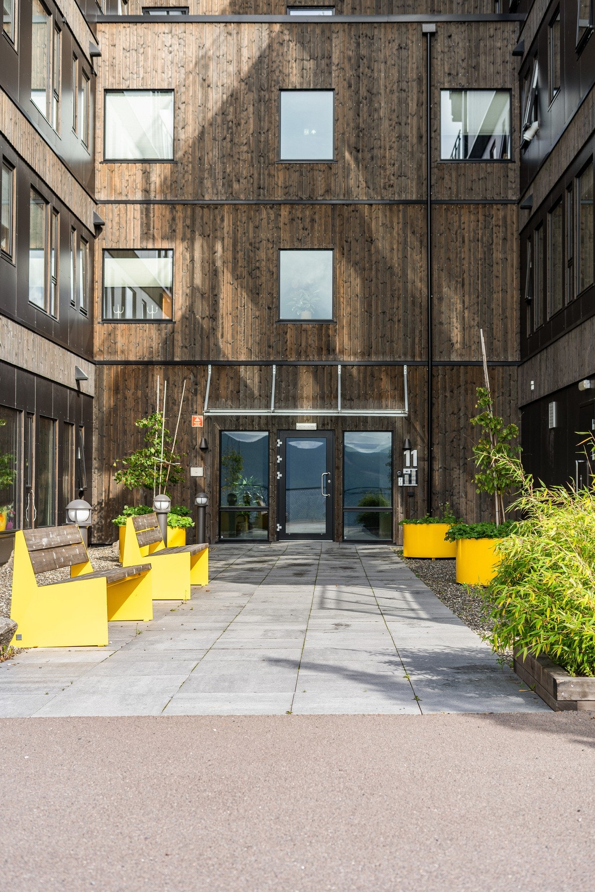 Innbydende inngangsparti med beplantning og sitteplasser. Galleribilde