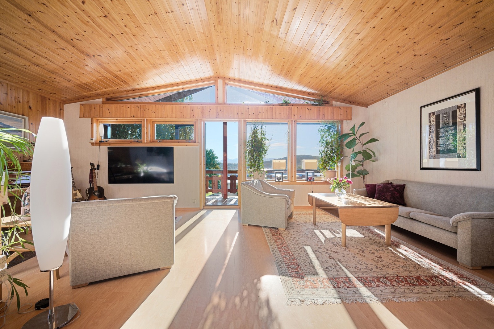 Skråtak og vinduenes utforming lyser opp hele stua med naturlig lys! Galleribilde