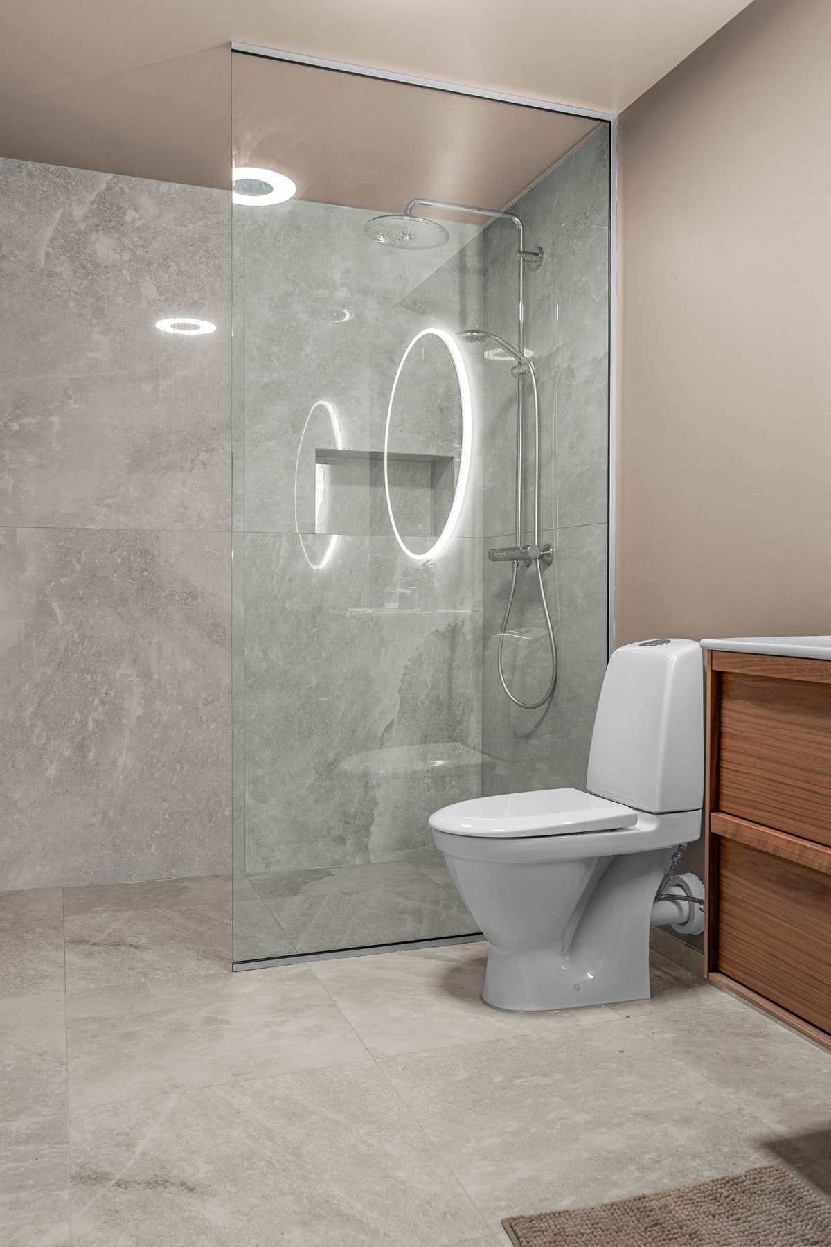 Utstyrt med dusjhjørne med regndusjhode, toalett, servant, servantskap, og rundt speil med belysning rundt. Galleribilde