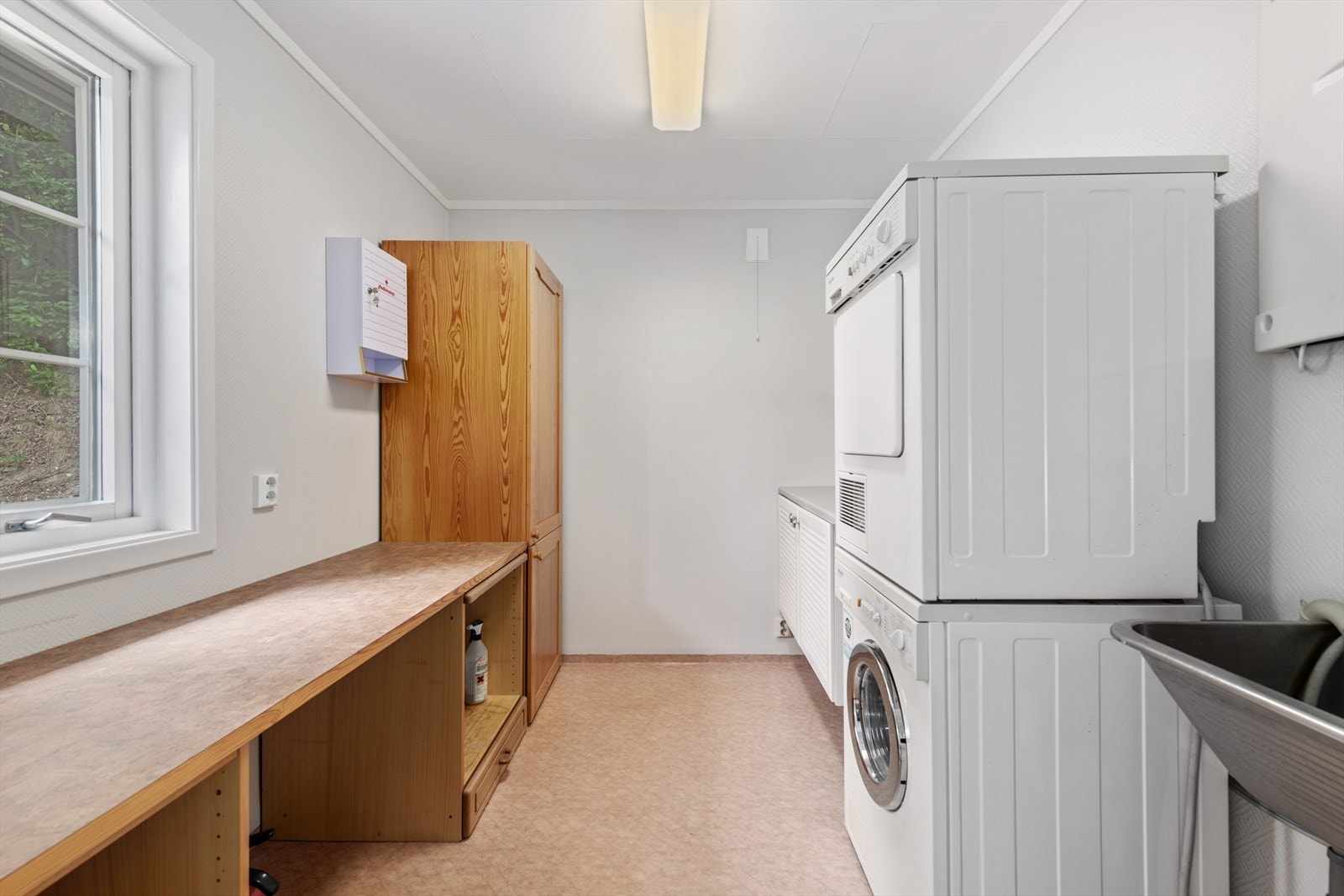 Separat praktisk vaskerom med innredning, skyllekum og opplegg for vaskemaskin og tørketrommel. Galleribilde