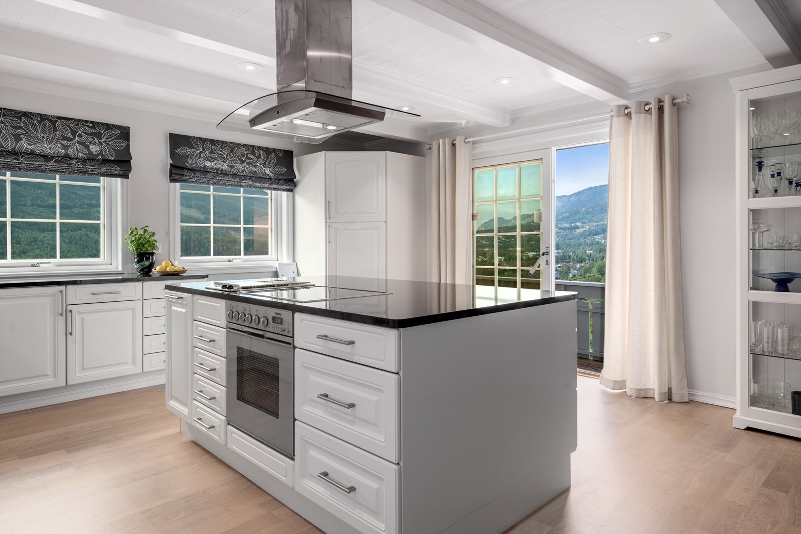 Kjøkkenøy med integrert platetopp og egen elektrisk grillplate, i tillegg til stekeovn fra Miele. Takhengt ventilator. Galleribilde