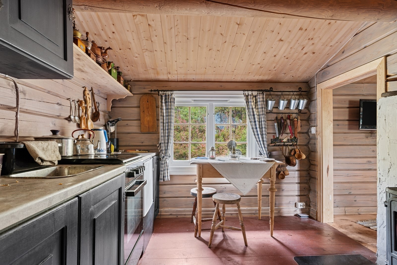 Plass for spisebord på kjøkken. Det er også ildsted på kjøkkenet. Galleribilde