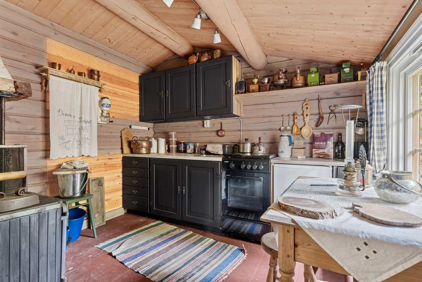 Kjøkkeninnredningen er i malt furu og består av skap og skuffer med overliggende benkeplate, samt flere overskap. Galleribilde