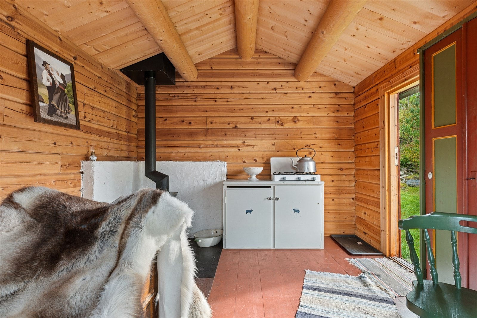 Gulvet er rødmalt og taket har solide tømmerbjelker. Galleribilde