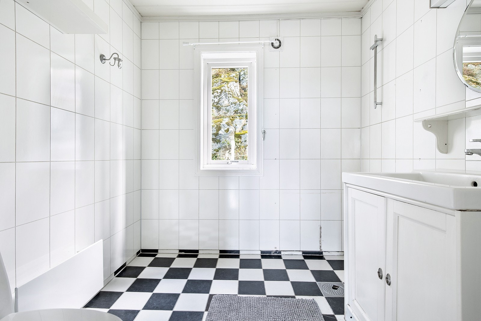 Baderom med fliser på gulvet og våtromsplater på veggene. Rommet må oppgraderes. Galleribilde