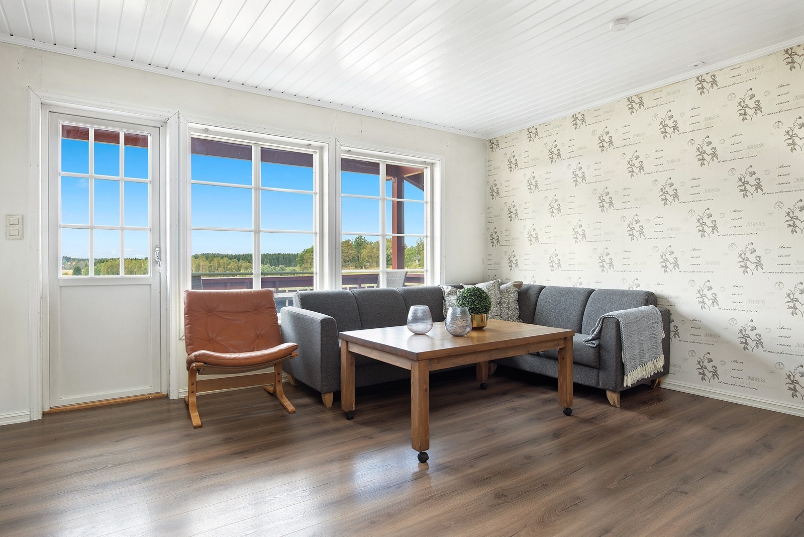 Oppe er det en lys stue med utgang til veranda. Galleribilde