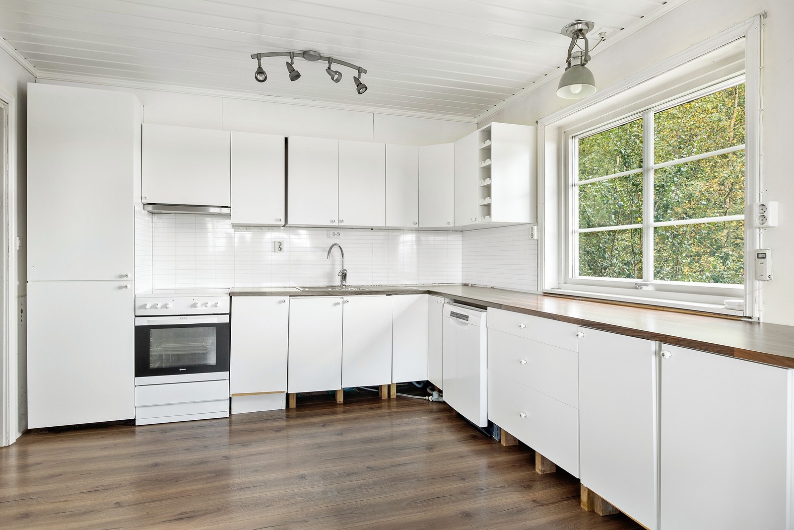 Lyst kjøkken med glatte fronter og benkeplate av laminat. Galleribilde