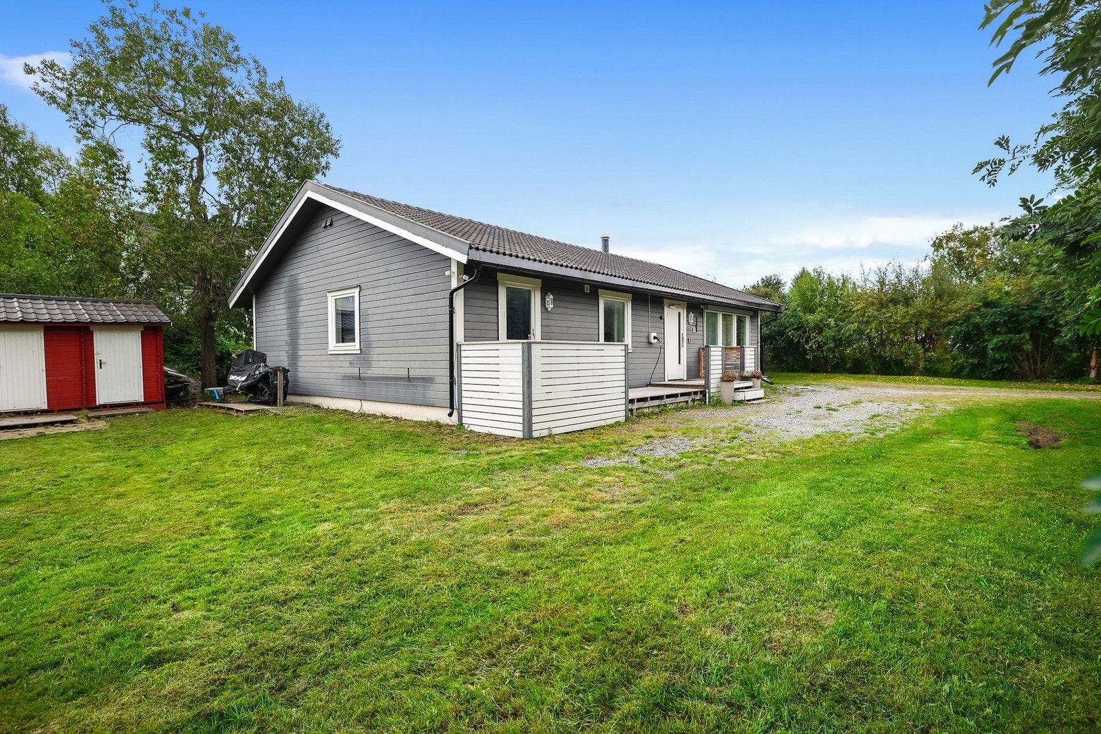 Boligen har et fint uteområde med hage og hekk rundt store deler av eiendommen. Galleribilde