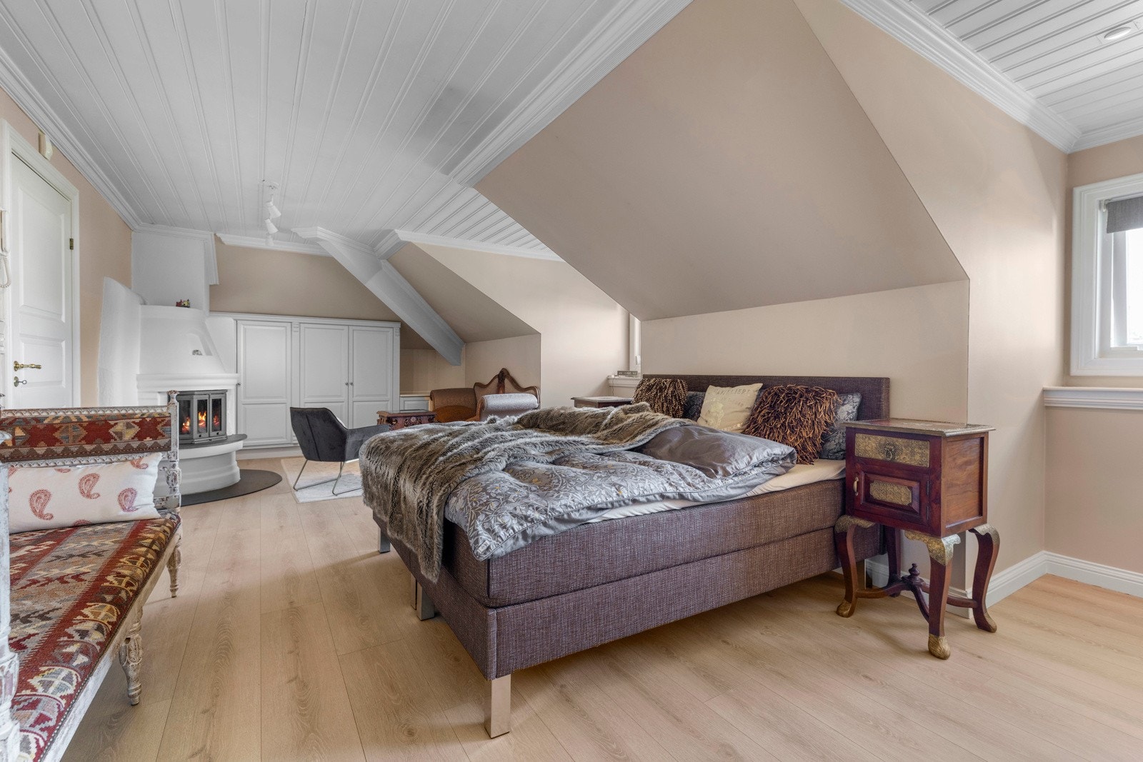 Her får du et luftig og innbydende hovedsoverom med god plass til dobbeltseng, skapplass og en koselig sofagruppe foran peisen.