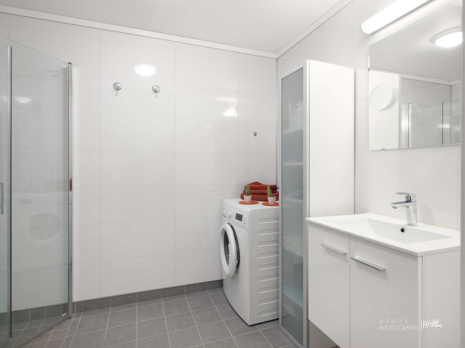 Lyst, flislagt bad med opplegg for vaskemaskin Galleribilde