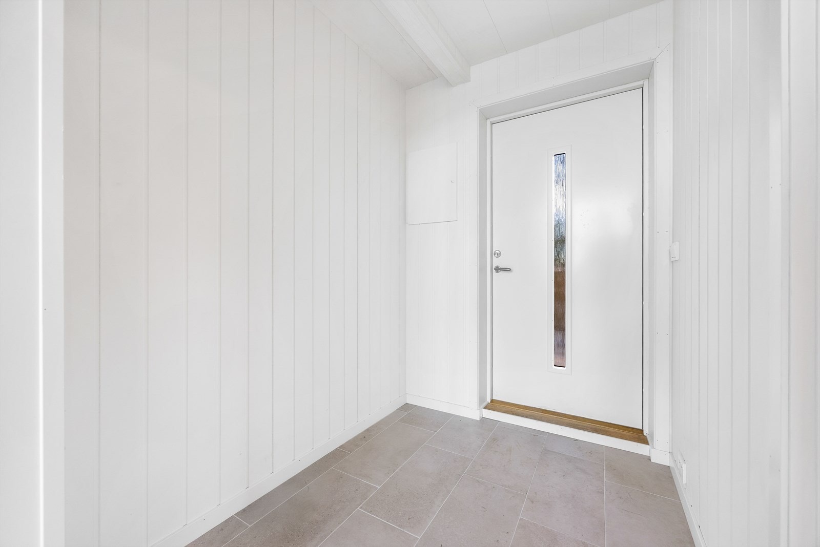 Lys entré med flislagt gulv og vannbåren varme. Galleribilde