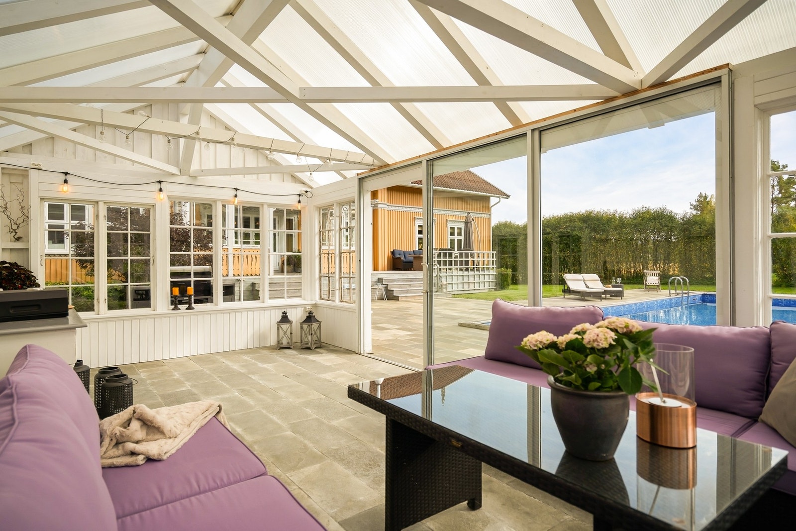 Ved bassenget ligger et stilfullt bassenghus/utestue, belagt med skifer og med vannbåren gulvvarme som gir komfort året rundt Galleribilde