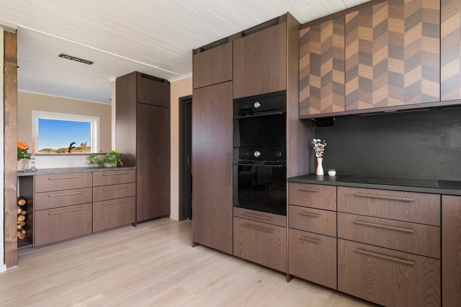 Innredning med underskap og takhøye overskap samt integrerte hvitevarer. Galleribilde