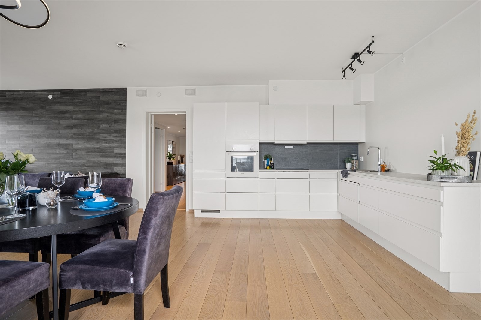 Moderne og stilrent kjøkken med glatte hvite fronter og laminat benkeplate. Galleribilde