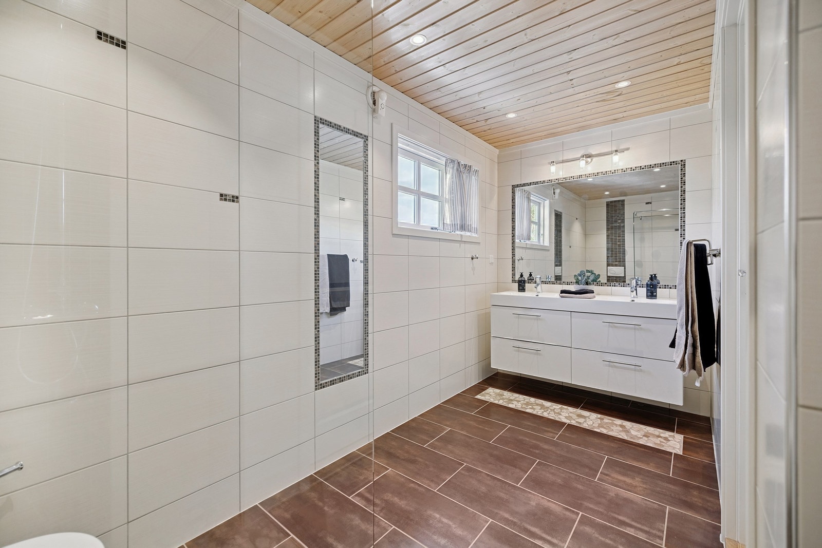 Flislagt bad fra 2020 med bred servantseksjon med doble servanter. Elektrisk gulvvarme. Galleribilde