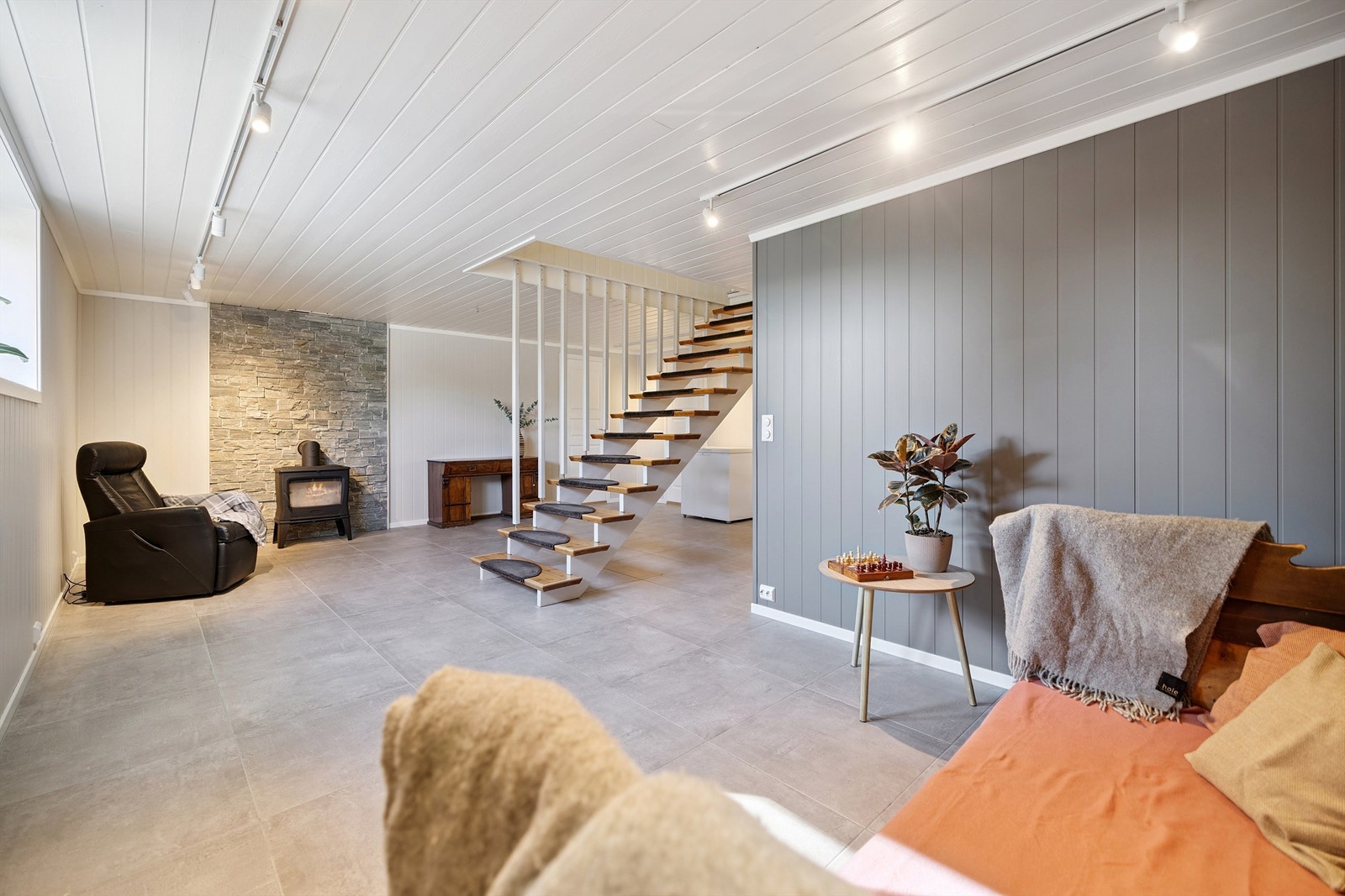 Romslig kjellerstue med peisovn og varmekabler i gulvet - et flott tilleggsareal. Rommet er ikke godkjent til varig opphold. Galleribilde