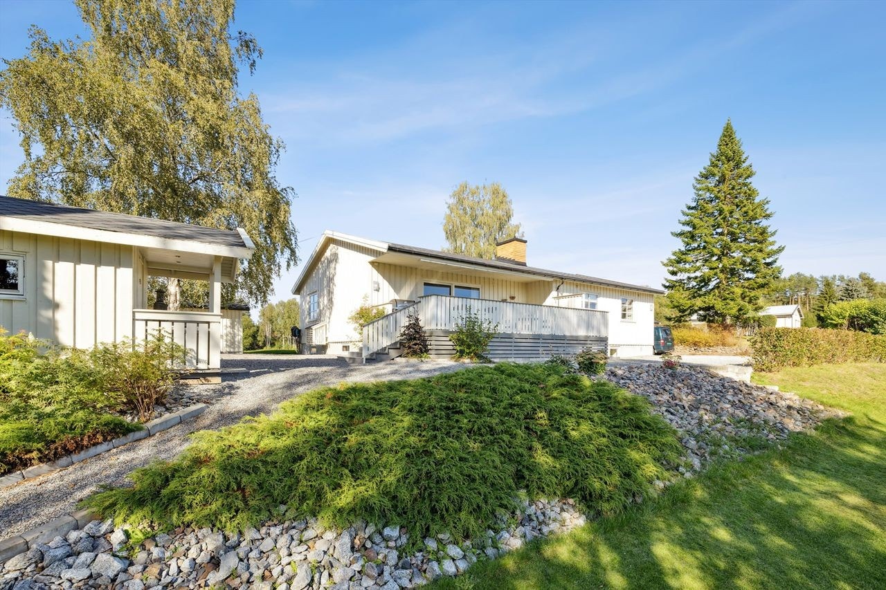 Solrik tomt som er pent opparbeidet med plen og diverse beplantning. Galleribilde