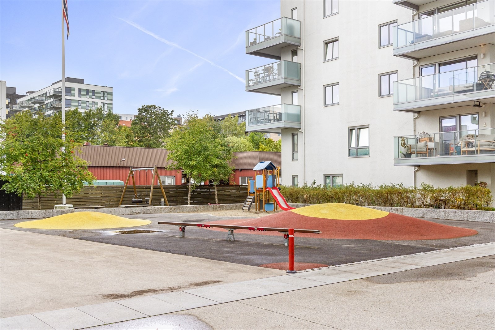 Pent opparbeidet uteområde med lekeplass, sittegrupper, beplantning og internveier. Galleribilde