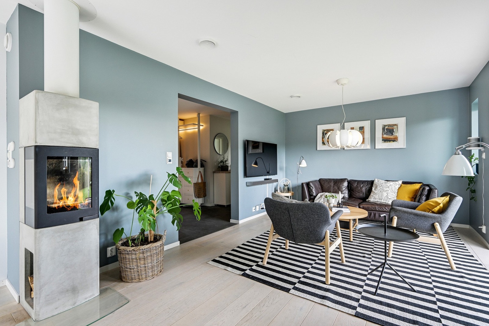 Boligens samlingspunkt er i denne hyggelige stuen med lekker peisovn og svært god plass til møblement. Her kan man ha sosiale sammenkomster, uten å bekymre seg for plassmangel. Galleribilde