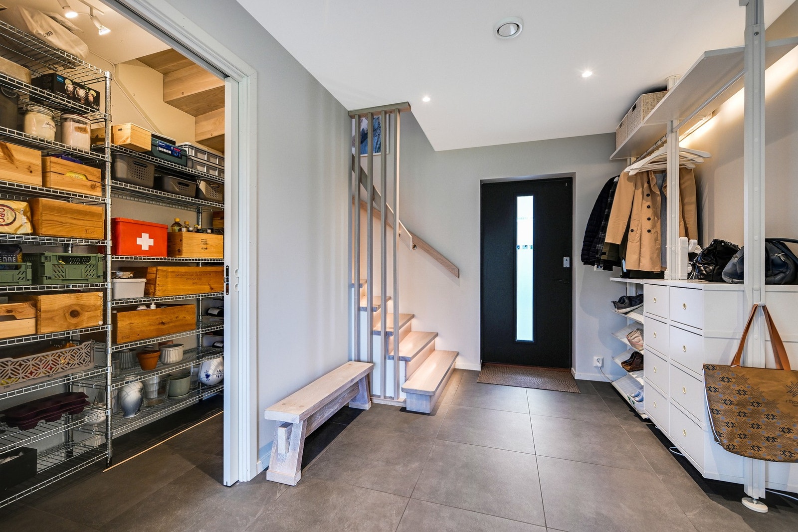 Under trappen, er det montert skyvedør inn til en smart oppbevaringsløsning -perfekt for en familie med mange ting å holde styr på. Galleribilde