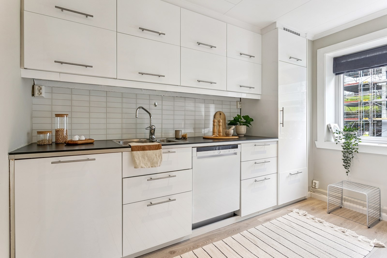 Pent hvitt kjøkken med god skap -og benkeplass. Galleribilde