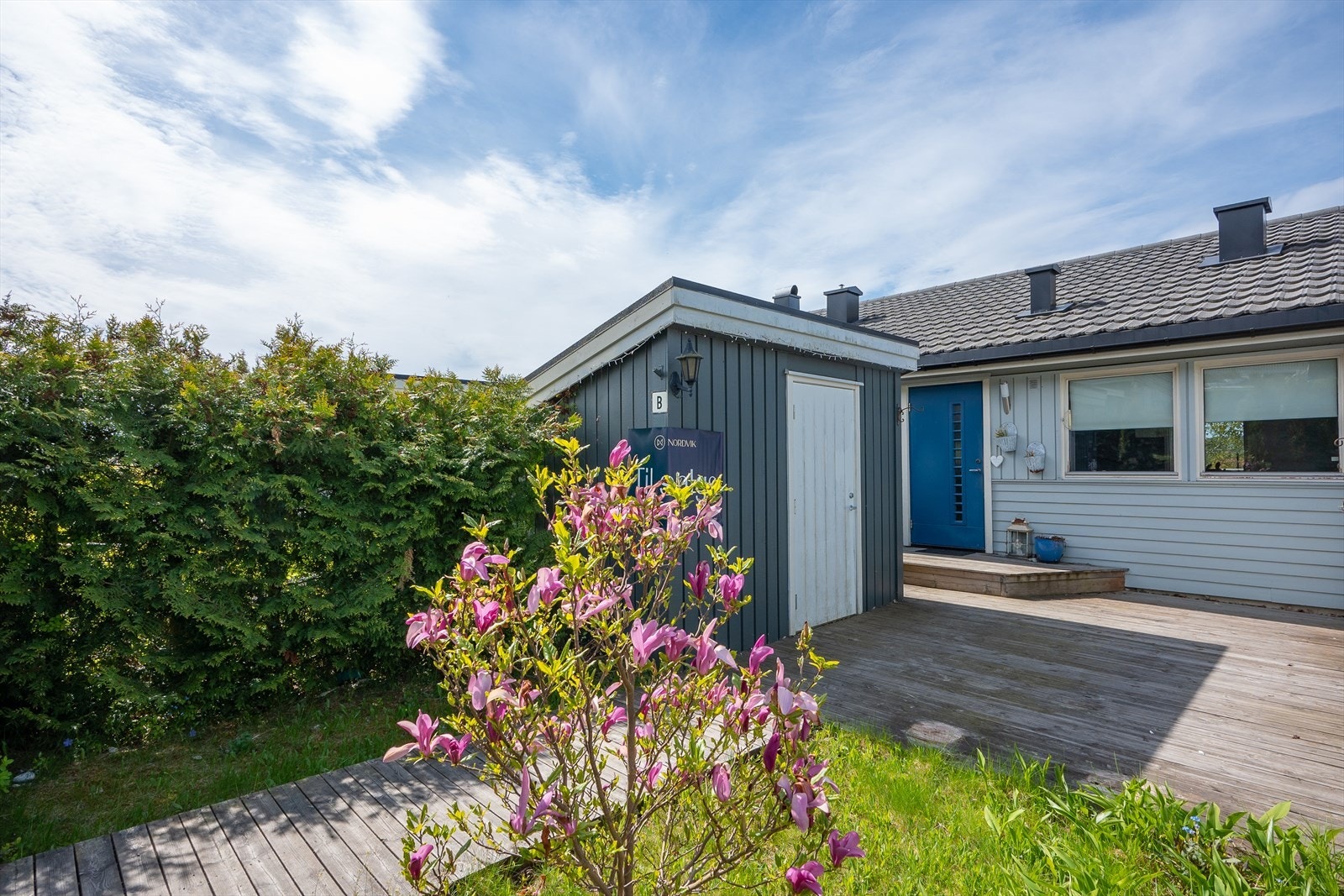 Inngangspartiet er opparbeidet med terrasse på 23 kvm, gressplen og div. beplanting, samt plass til utemøblement der morgensolen kan inntas. Galleribilde
