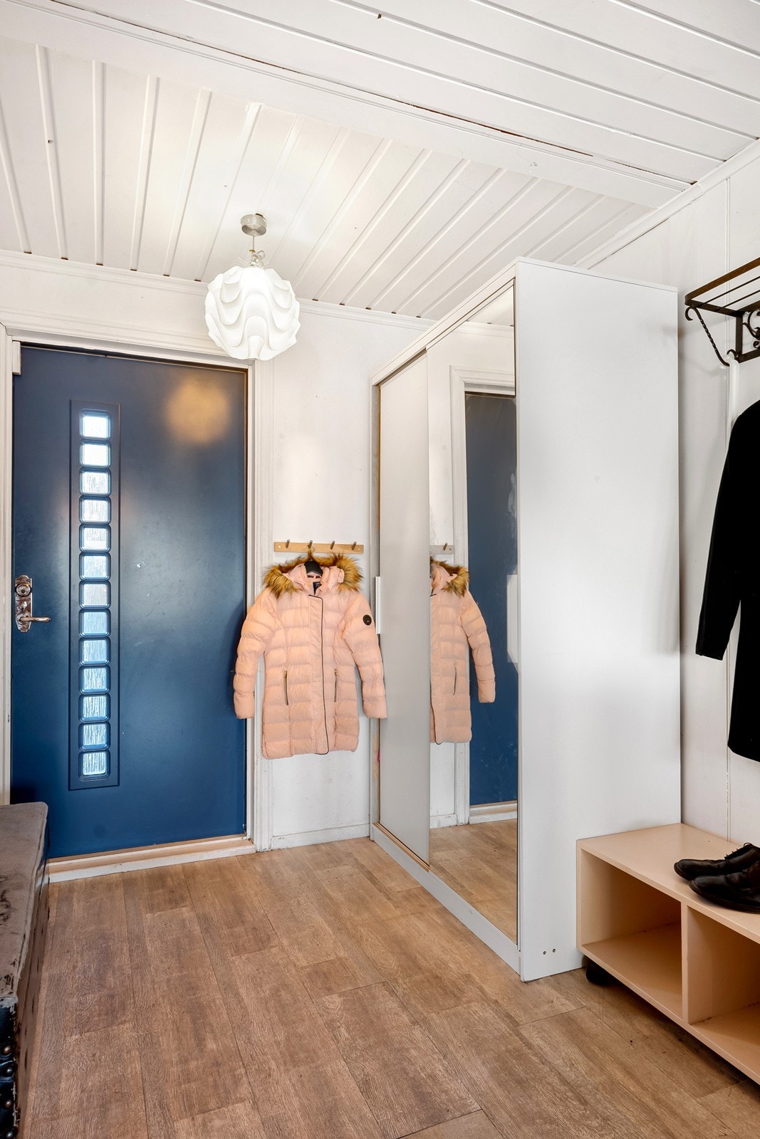 Vel inne i boligens 1.etasje er en lys og åpen entré inn mot stueområdet, med garderobeskap, hattehylle og knagger. Galleribilde