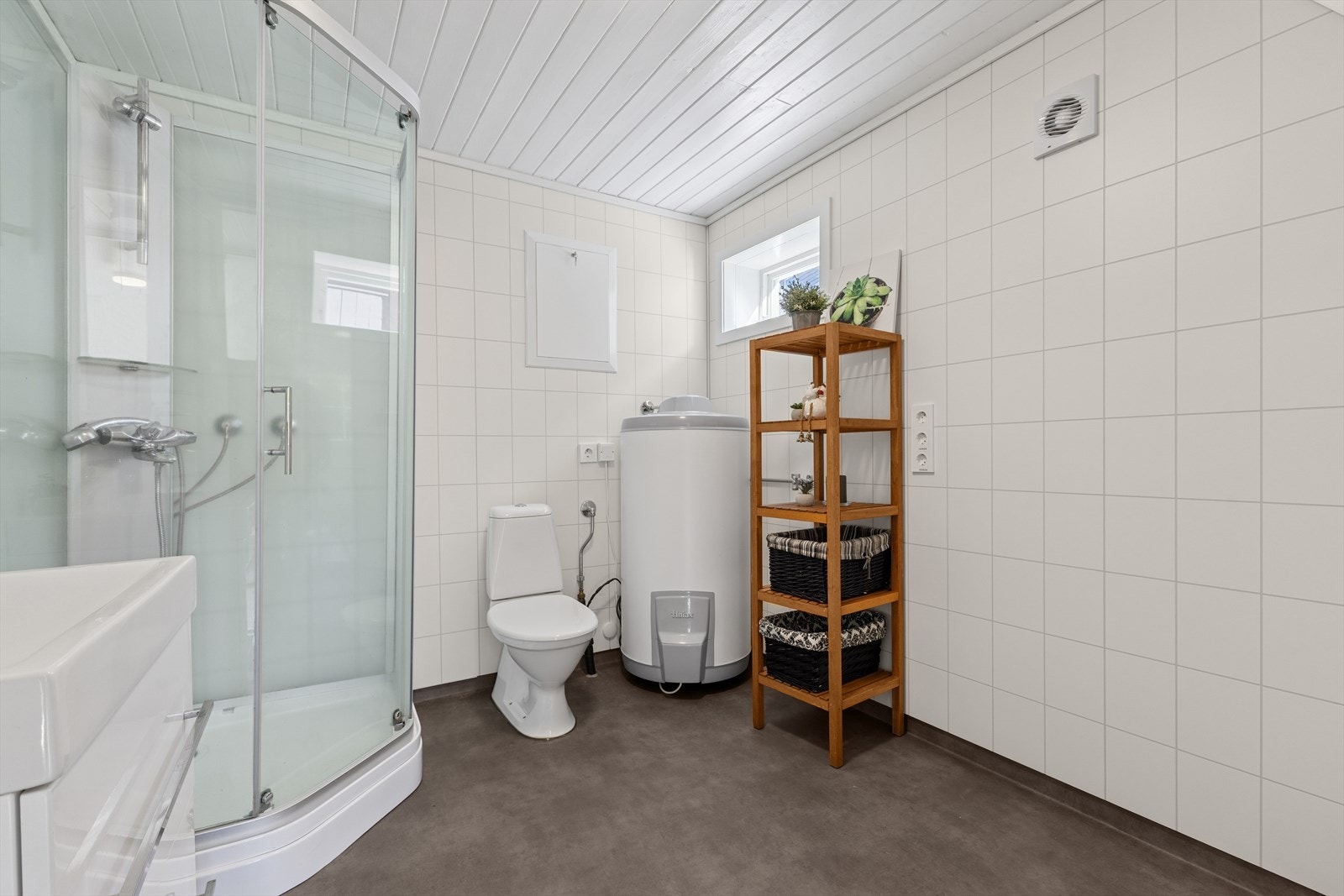 Standard toalett, servantinnredning, dusjkabinett og opplegg for vaskemaskin. Elektrisk avtrekksvifte og tilluftsspalte i dør. Galleribilde