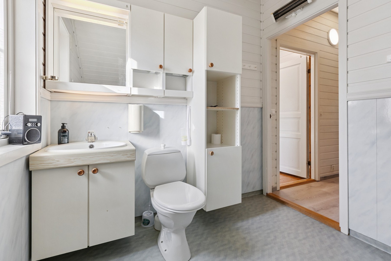 Badet inneholder romslig baderomsinnredning med servant, toalett og badekar Galleribilde