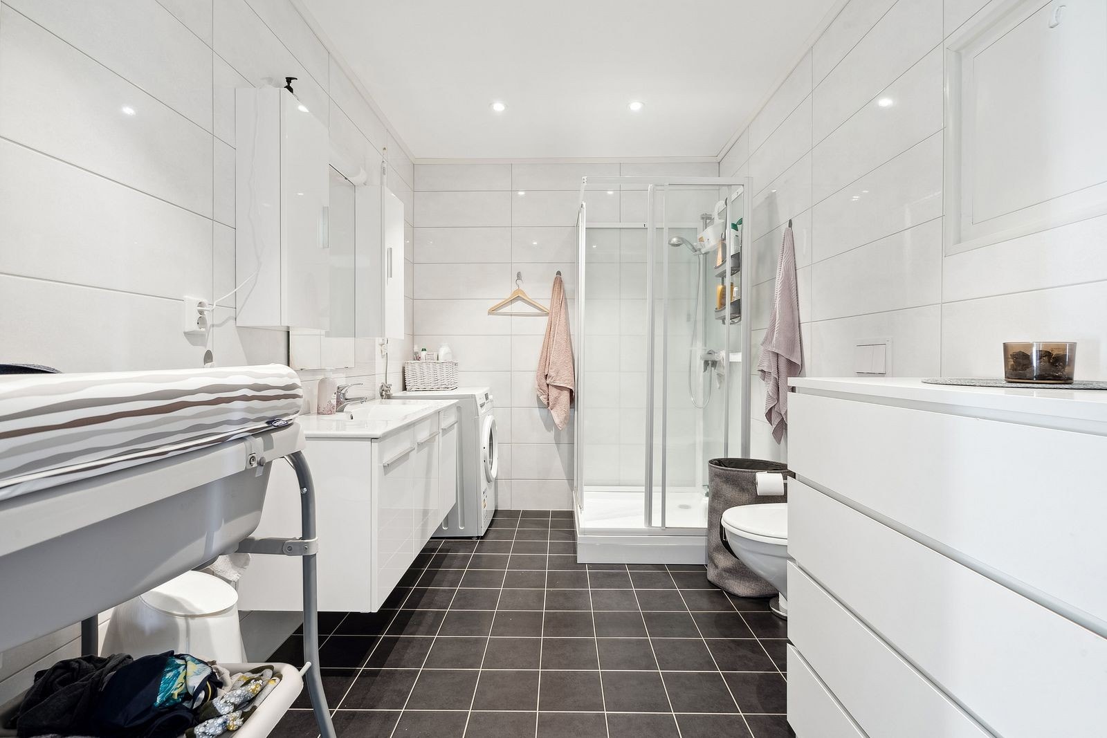 Rommet er utstyrt med servant på skapinnredning, veggmontert toalett,
dusjkabinett og opplegg for vaskemaskin. Galleribilde