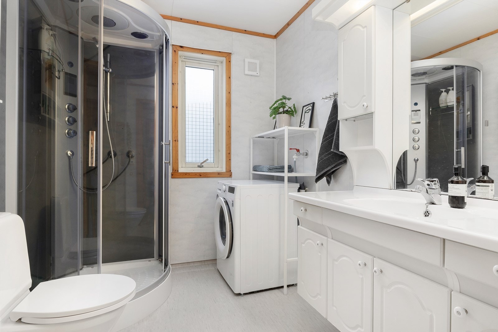 Badet har varmekabler i gulvet, dusjkabinett, toalett, innredning og uttak for vaskemaskin. Galleribilde