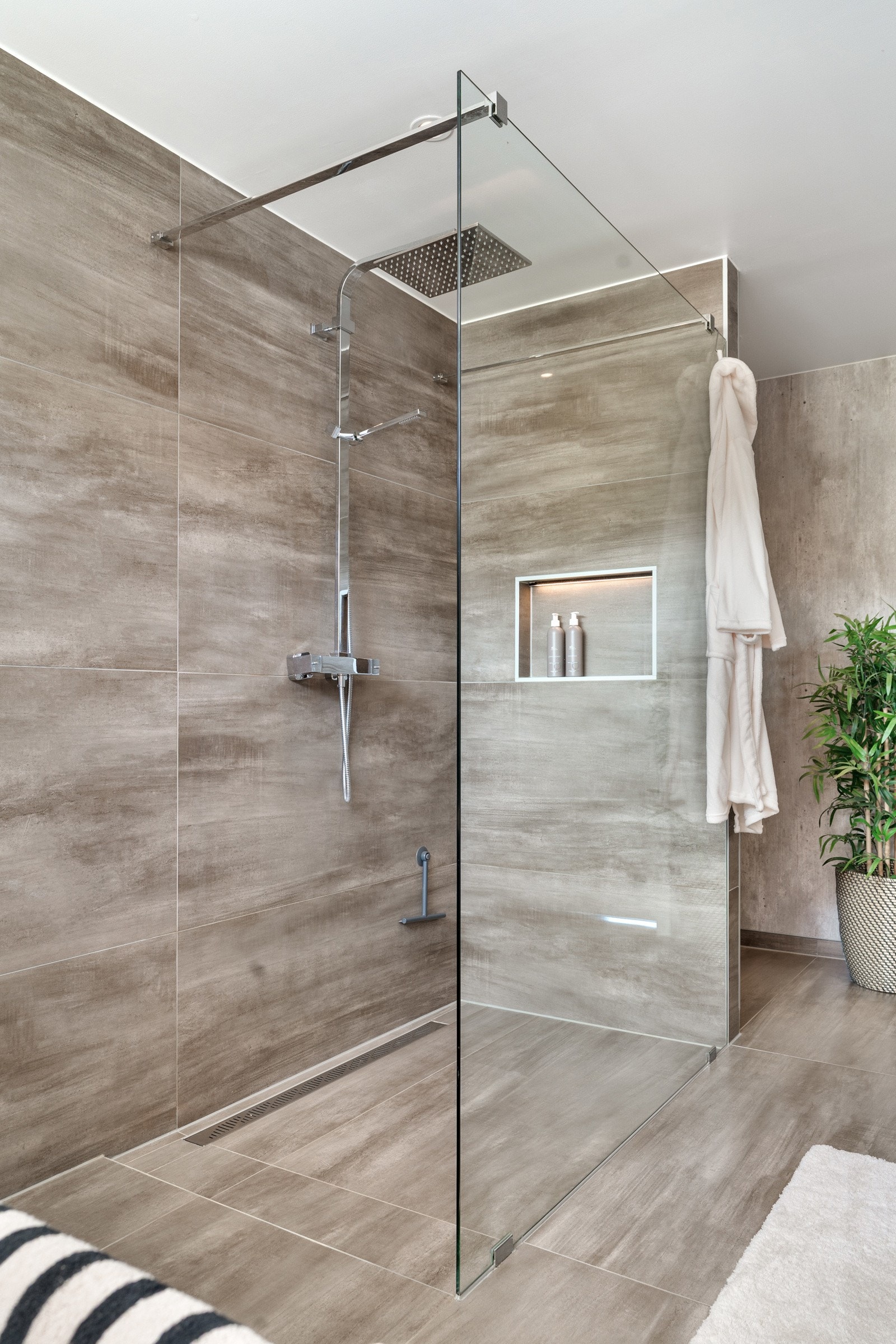 Det er flotte fliser på gulv og vegg, med et romslig dusjhjørne med regndusj. Galleribilde