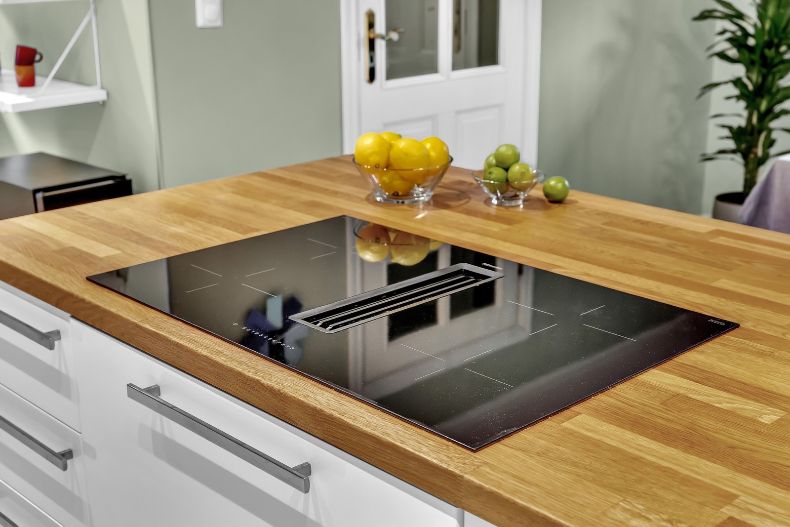 Stilig og praktisk platetopp med innebygd kullfiltervifte er montert i kjøkkenøya. Galleribilde