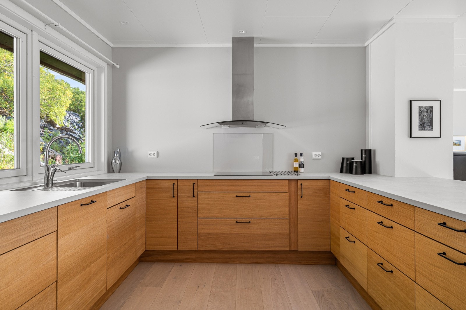 Kjøkkeninnredning fra Sigdal av laminerte skrog med laminerte slette fronter, laminert benkeplate med nedfelt oppvaskkum i stål.