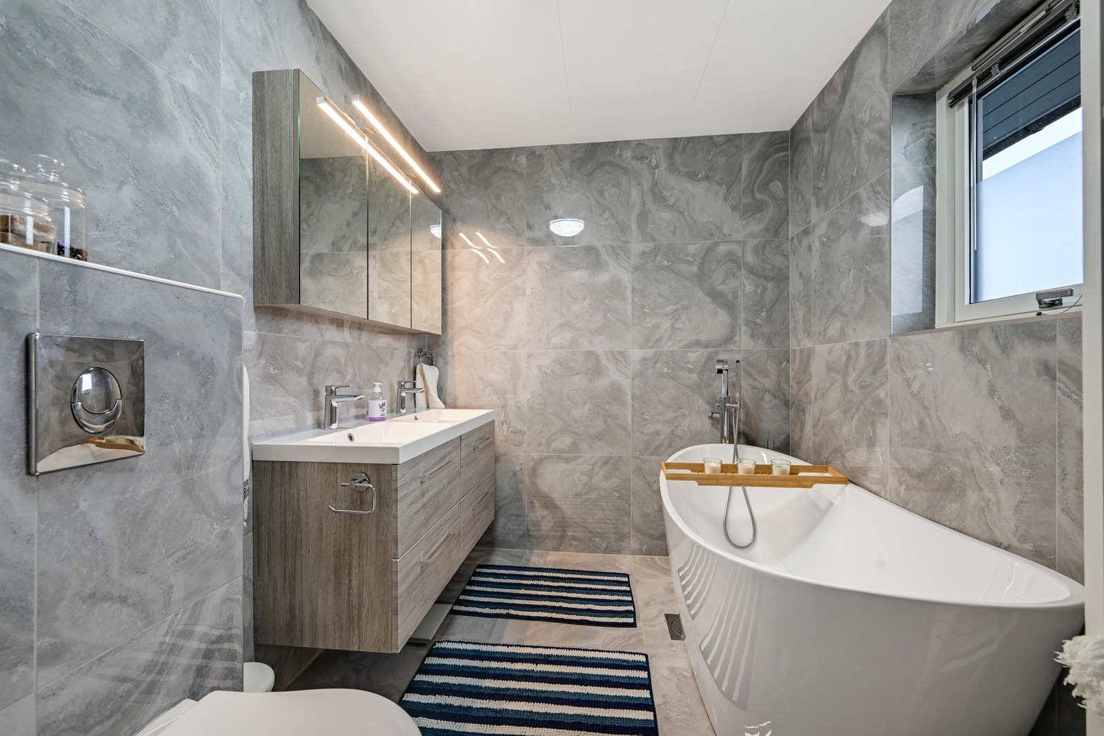 Baderom nr. 2 befinner seg i 2. etasje og tilbyr et pent badekar hvor late dager kan nytes med en kald forfriskning. Pen innredning med overskap og underskuffer i en innredning med dobbel servant. Galleribilde