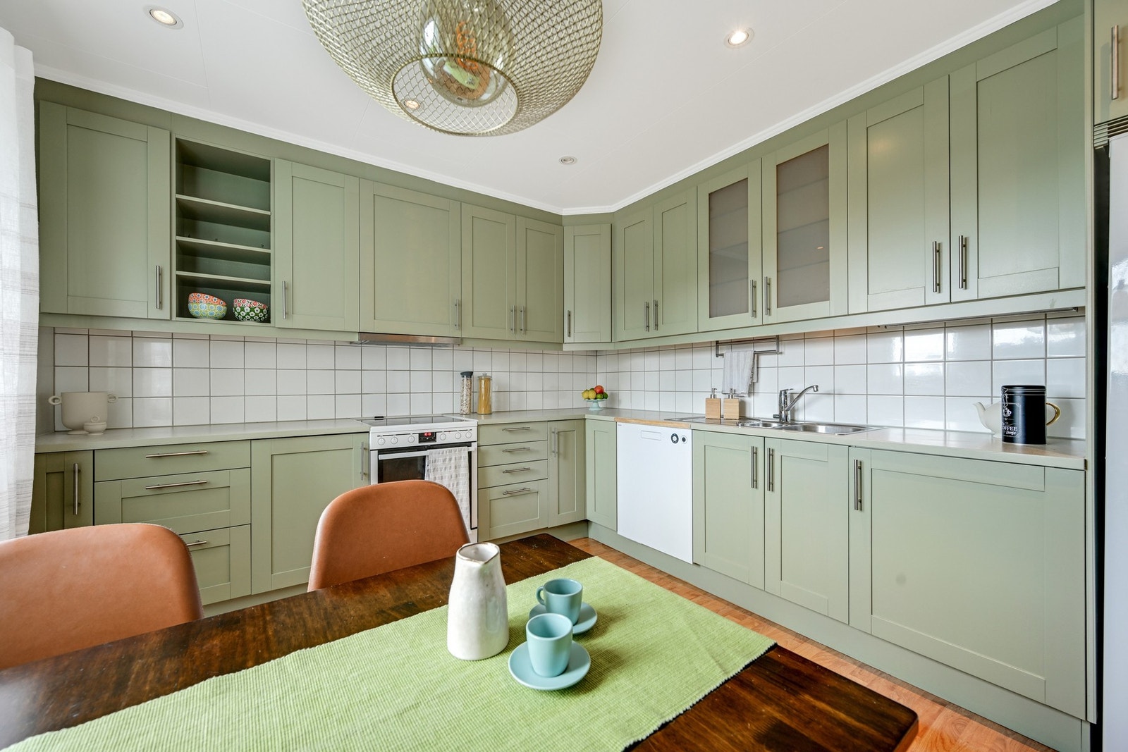 Flott kjøkken med takhøye overskap som ble malt opp i år Galleribilde