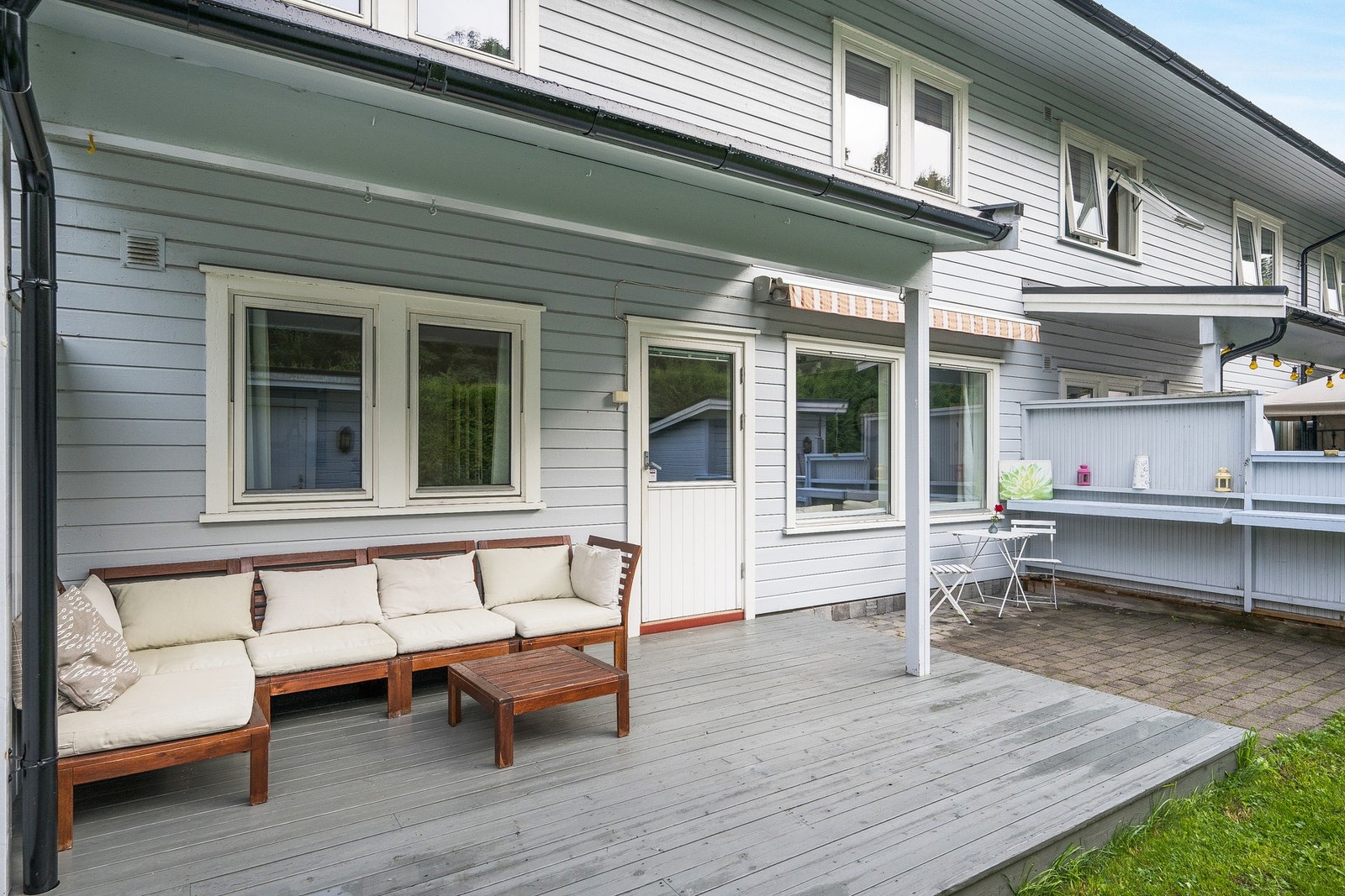 Terrassen er delvis overbygd med tak, samtidig som det er montert markise som gir ly fra et lite regnskur. Galleribilde