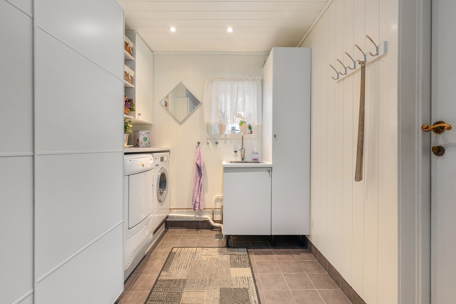 Vaskerommet er eit praktisk rom for barnefamiliar, og rommet er utstyrt med opplegg for vaskemaskin, plass til tørketrommel og vask. Vaskerommet har fliser på golv og mdf-plater på vegger. Galleribilde