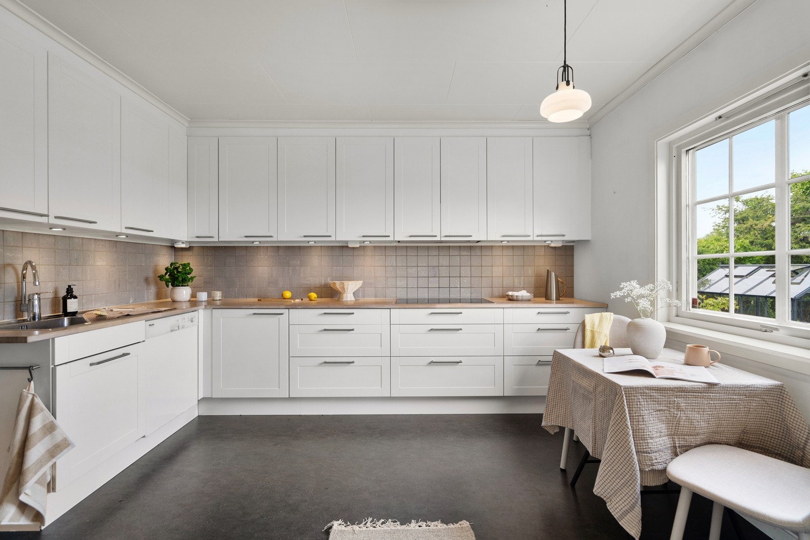 foto-003Kjøkkenet er lyst og innbydende, med god benkeplass og mange skap. Det ble oppgradert med et Svane-kjøkken i 2012, og har hvite, slette fronter samt fliser over benk. Galleribilde