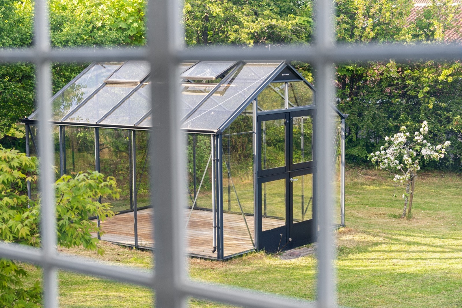 Rommet preges av store vindusflater som slipper inn rikelig med naturlig lys, og peisovnen skaper en lun og koselig atmosfære Galleribilde