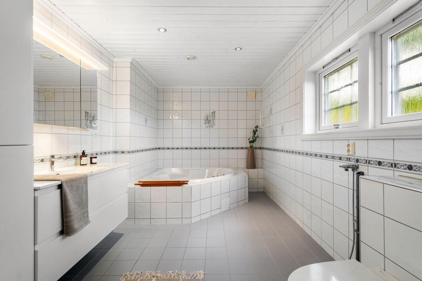 Badet i hovedetasjen er romslig og delikat, med lyse fliser som gir en ren og behagelig atmosfære Galleribilde