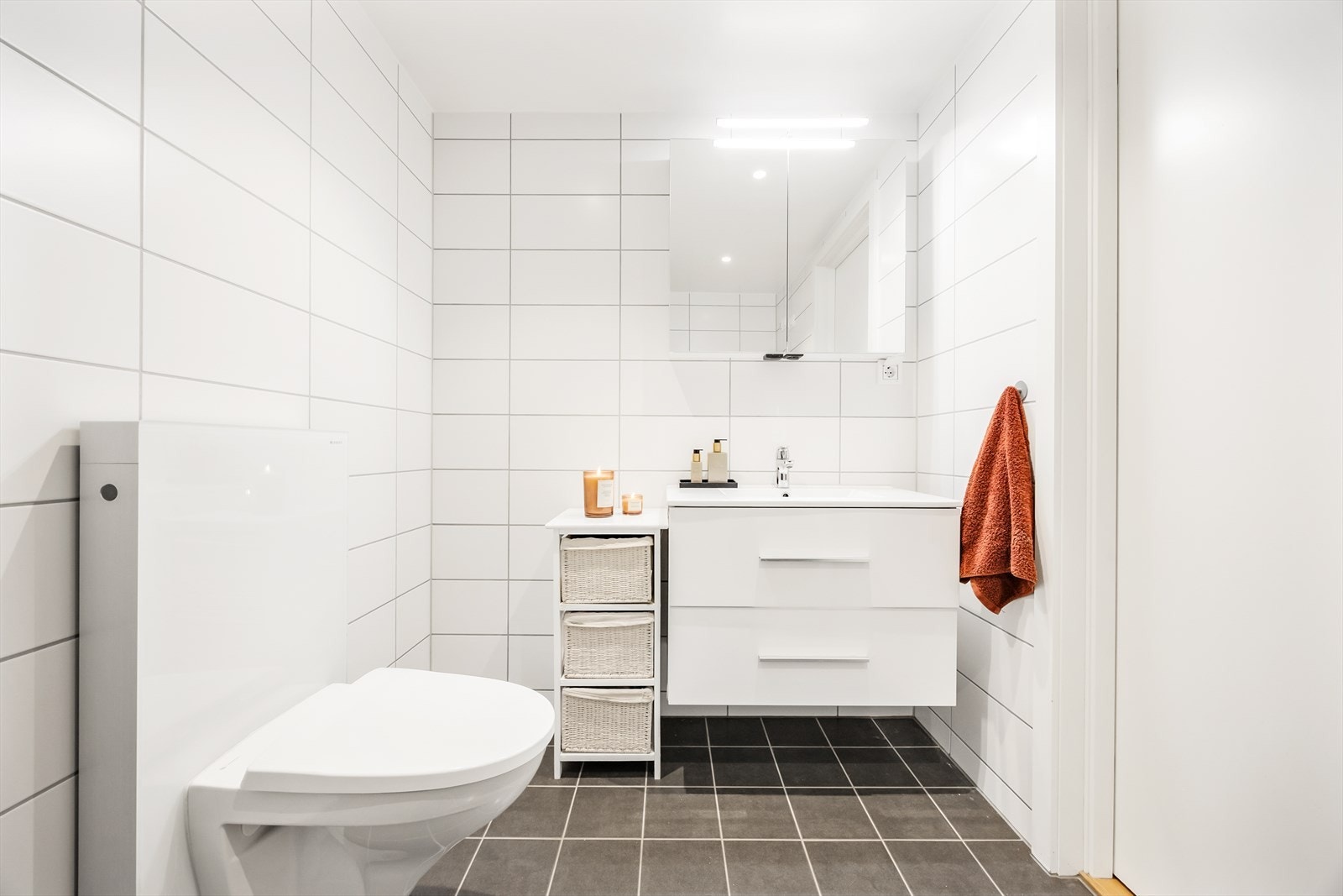 Badet er pent innredet med skuffeseksjon, dusjsone med innfellbare dusjvegger og vegghengt toalett.
Opplegg for vaskemaskin og tørketrommel. Galleribilde