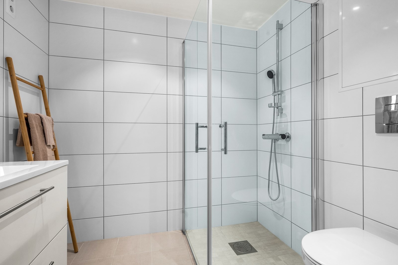 Her får du veggmontert innredet servant- og toalett, opplegg for vaskemaskin samt praktiske innfellbare dusjdører. Galleribilde